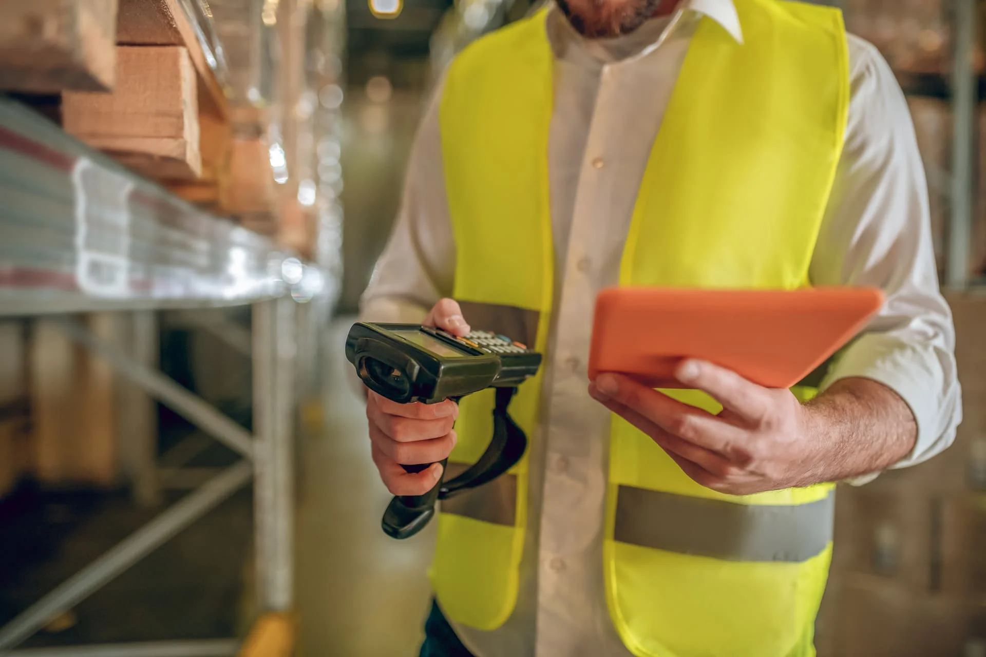 Homme avec un gilet jaune en train de scanner des palettes