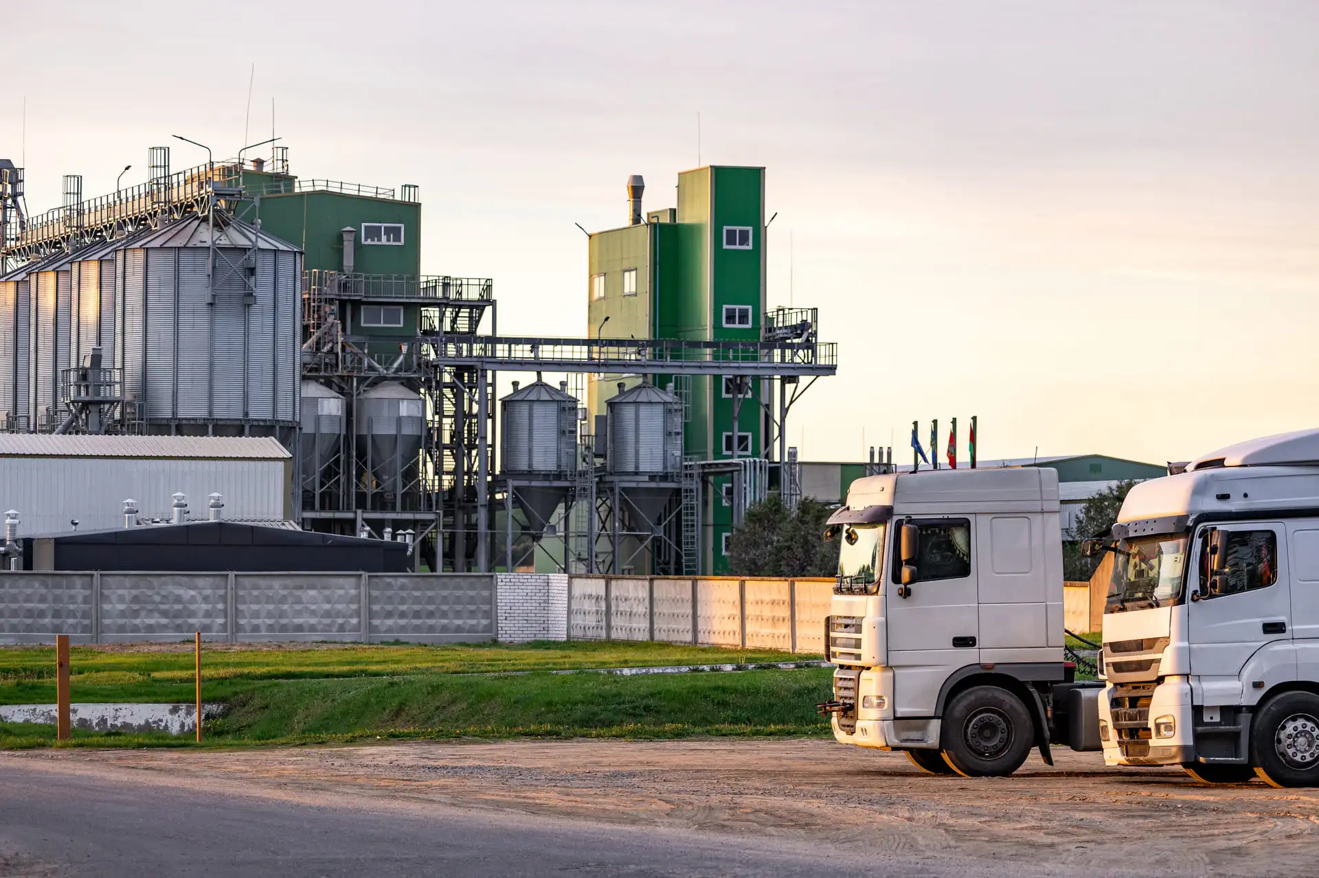 Deux camions blanc devant une usine agricole
